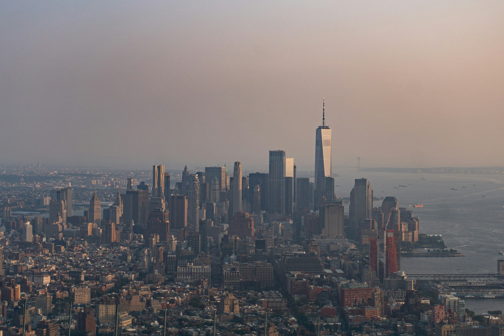 Real photograph of the Lower Manhattan skyline at sunset, representing the Downtown neighborhoods Labinot Alidemaj serves